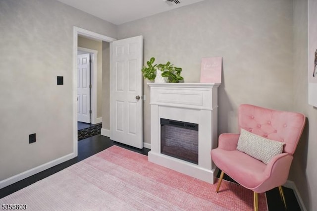 sitting room featuring a fireplace and baseboards