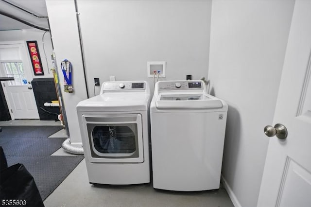 clothes washing area with washing machine and dryer
