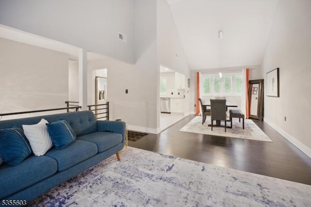 living area featuring high vaulted ceiling, wood finished floors, and baseboards
