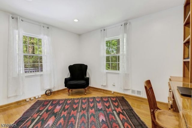 sitting room featuring plenty of natural light, wood finished floors, recessed lighting, and baseboards