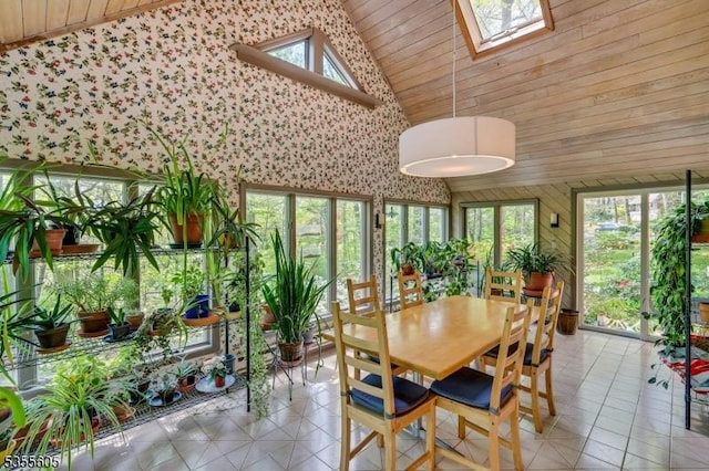 sunroom / solarium featuring a skylight, high vaulted ceiling, tile patterned floors, and wooden ceiling