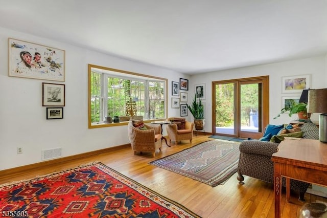living area with plenty of natural light, wood finished floors, and baseboards