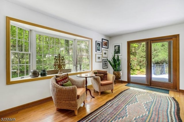 sitting room with healthy amount of natural light, wood finished floors, and baseboards