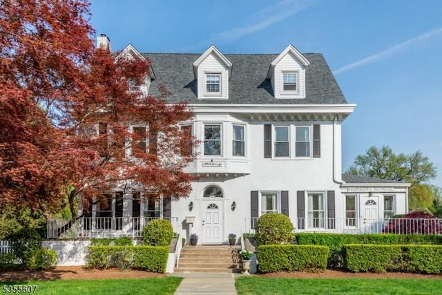 view of front of home featuring a chimney and stucco siding