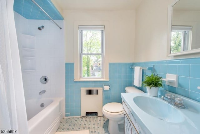 bathroom featuring radiator, tile patterned flooring, wainscoting, tile walls, and shower / bath combo