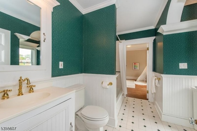 bathroom with wainscoting, ornamental molding, toilet, vanity, and tile patterned floors