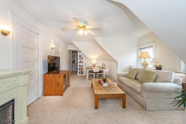 living room featuring light carpet, a fireplace, ceiling fan, and lofted ceiling