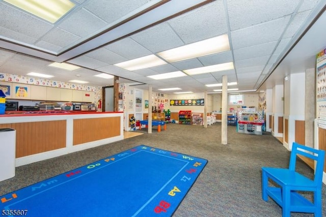 rec room with carpet flooring and a paneled ceiling