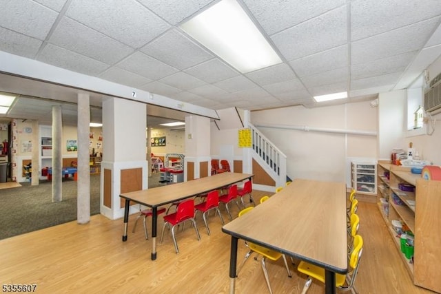 playroom featuring a drop ceiling and wood finished floors
