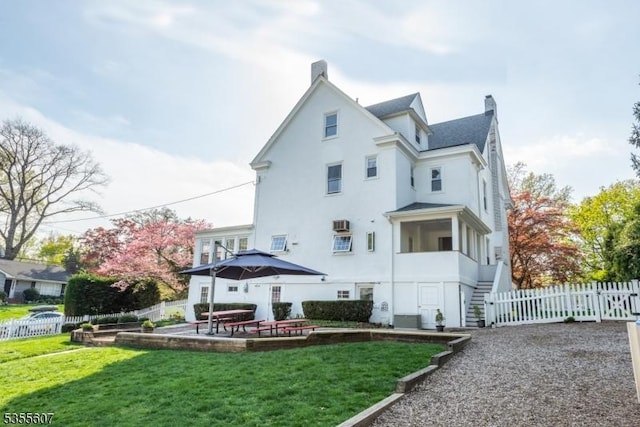 rear view of property featuring stucco siding, a chimney, and a patio