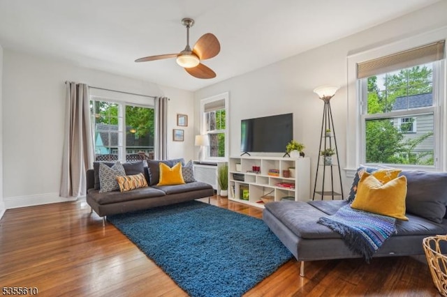 living room with wood finished floors, ceiling fan, and baseboards