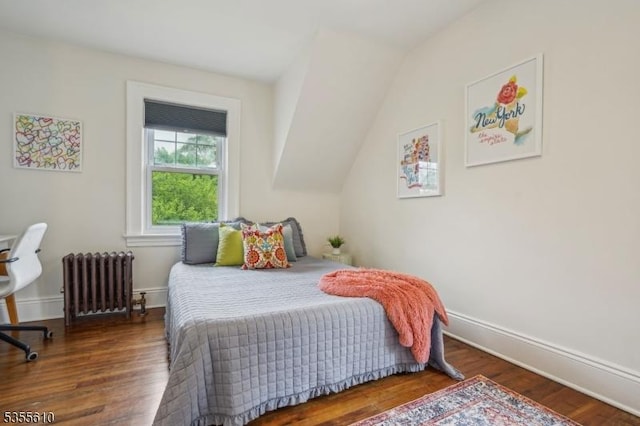 bedroom with radiator, wood finished floors, and baseboards