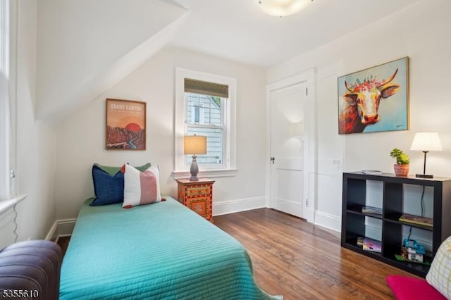 bedroom featuring wood finished floors, baseboards, and vaulted ceiling