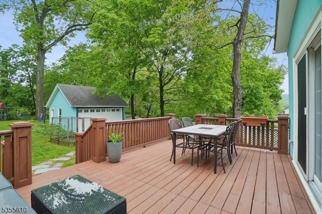 wooden deck with outdoor dining space, an outdoor structure, and view of wooded area