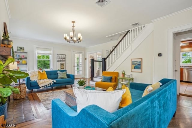 living room featuring plenty of natural light, stairway, a chandelier, and ornamental molding