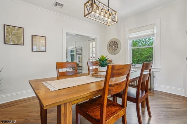 dining area with baseboards, ornamental molding, dark wood-type flooring, and a chandelier
