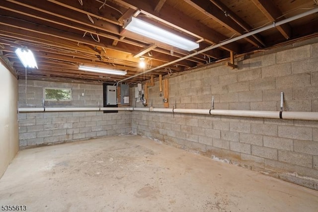 unfinished below grade area featuring electric panel and concrete block wall
