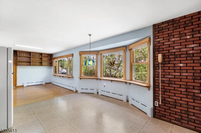 interior space featuring a baseboard heating unit, light floors, and brick wall