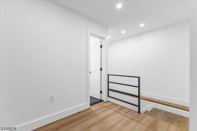 spare room featuring recessed lighting, baseboards, and wood finished floors