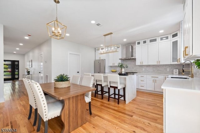 dining area featuring light wood-style floors, a chandelier, and recessed lighting