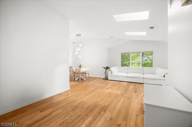 102 Westchester Ter, Clinton Twp, NJ 08801 - living room with a skylight, light wood-style flooring, vaulted ceiling, and baseboards