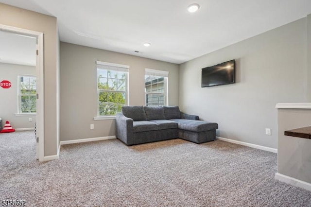 living room featuring carpet flooring, baseboards, and a wealth of natural light