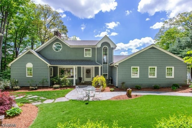 40 Hemlock Ave, Andover Twp, NJ 07860 - rear view of house with a chimney, a lawn, a shingled roof, and a patio area