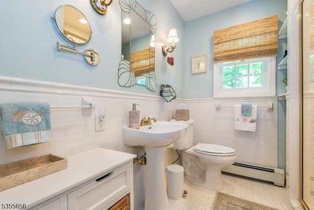 40 Hemlock Ave, Andover Twp, NJ 07860 - bathroom featuring a baseboard heating unit, toilet, a shower with shower door, wainscoting, and tile walls
