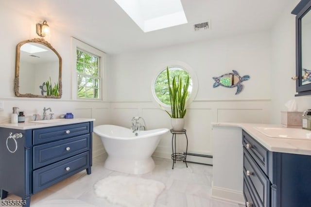 40 Hemlock Ave, Andover Twp, NJ 07860 - full bath featuring a skylight, a decorative wall, a freestanding tub, two vanities, and wainscoting
