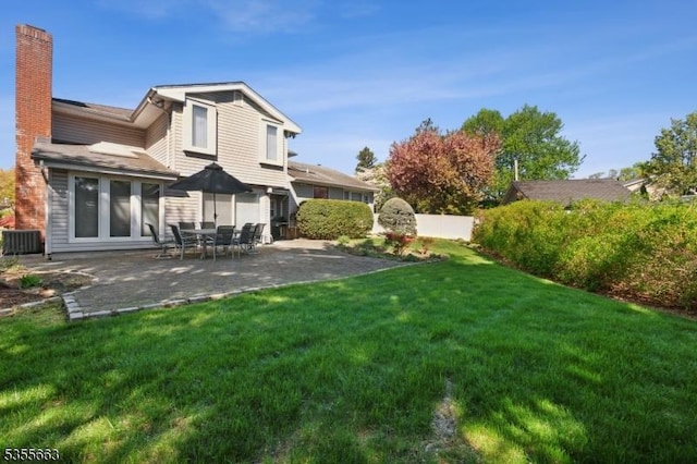 rear view of house featuring a chimney, a patio, and central AC