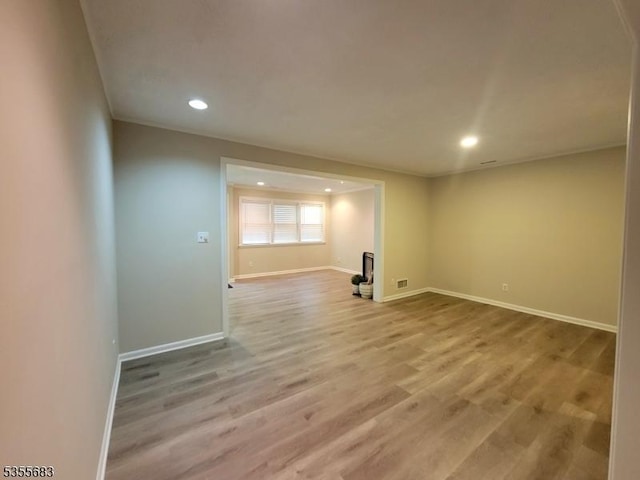 unfurnished room featuring recessed lighting, baseboards, wood finished floors, and ornamental molding
