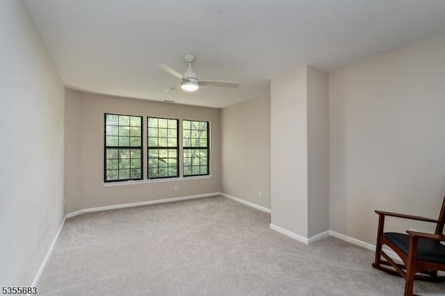 unfurnished room featuring light carpet, ceiling fan, and baseboards