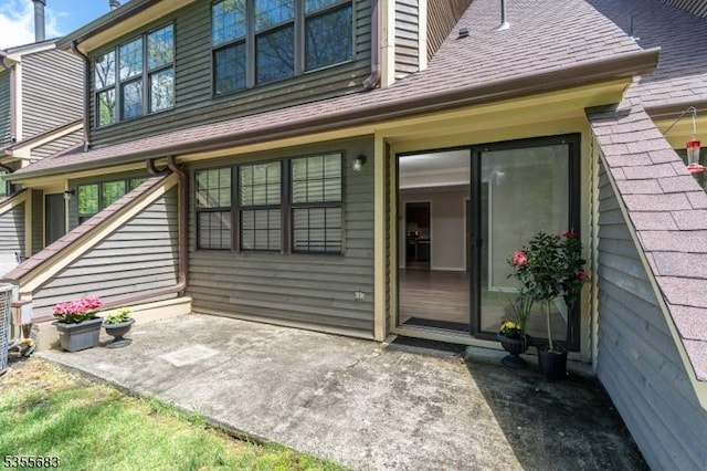 back of house featuring a patio area and a shingled roof