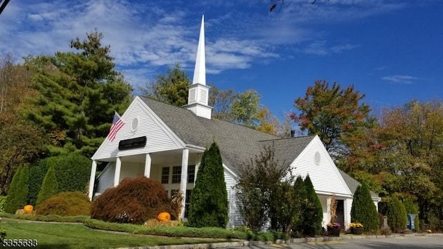 view of side of home featuring a chimney and roof with shingles