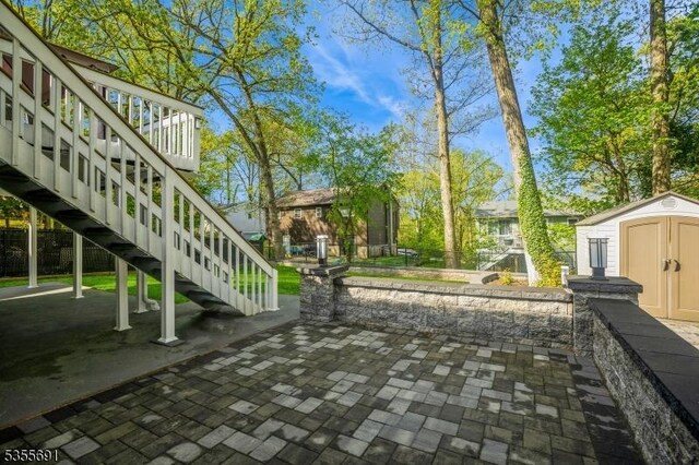 10 Tulsa Trl, Hopatcong Boro, NJ 07843 - view of property's community featuring a storage shed, fence, an outdoor structure, stairway, and a patio area