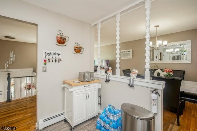 10 Tulsa Trl, Hopatcong Boro, NJ 07843 - interior space with a baseboard heating unit, an AC wall unit, white cabinets, and wood finished floors
