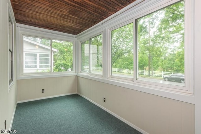 unfurnished sunroom with wooden ceiling, carpet flooring, and baseboards