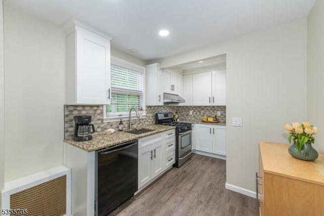 kitchen with stainless steel gas range, dishwasher, exhaust hood, a sink, and wood finished floors