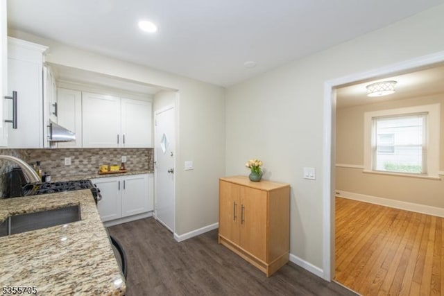 kitchen featuring range hood, dark wood-type flooring, white cabinets, and recessed lighting