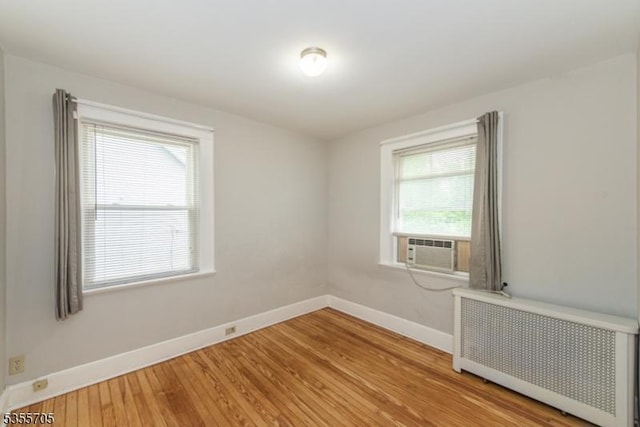 unfurnished room with radiator heating unit, baseboards, and plenty of natural light