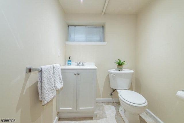 bathroom featuring toilet, baseboards, and vanity