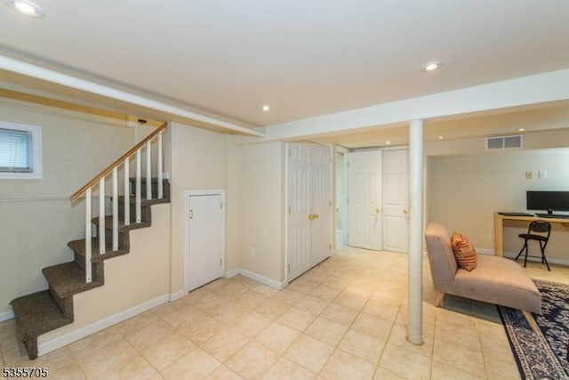 finished below grade area featuring stairway, recessed lighting, light tile patterned floors, and baseboards