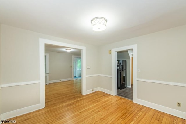 spare room featuring light wood-type flooring and baseboards