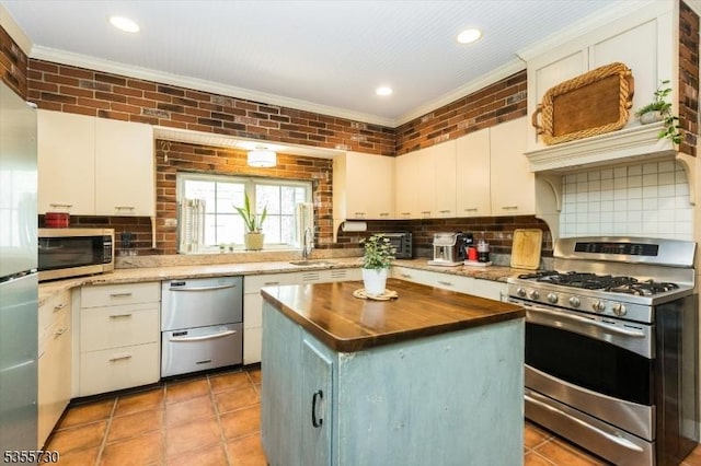 197 Nutley Ave, Nutley Twp, NJ 07110 - kitchen featuring appliances with stainless steel finishes, crown molding, wood counters, tasteful backsplash, and a center island