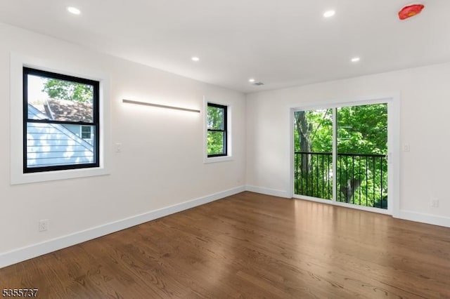 empty room with baseboards, recessed lighting, and wood finished floors