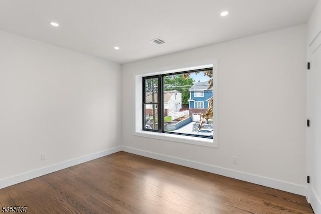 empty room featuring baseboards, wood finished floors, and recessed lighting