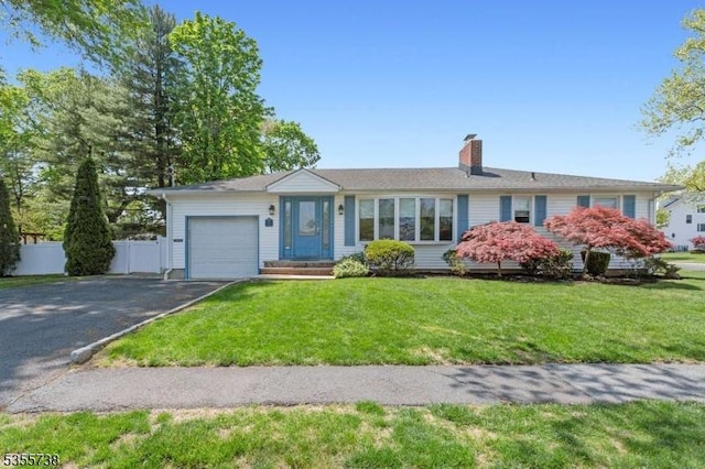 single story home featuring an attached garage, asphalt driveway, and a chimney
