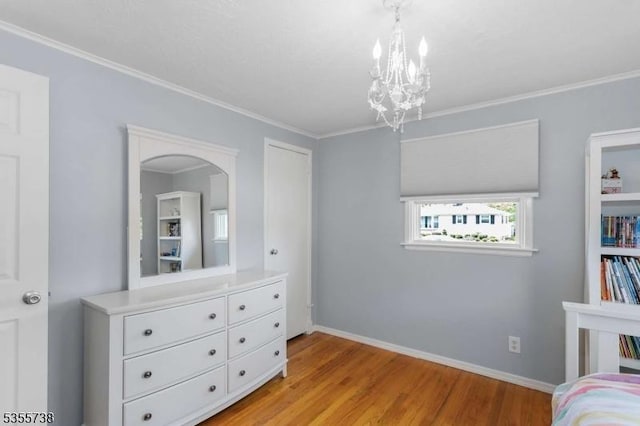 bedroom featuring light wood-style floors, a chandelier, crown molding, and baseboards