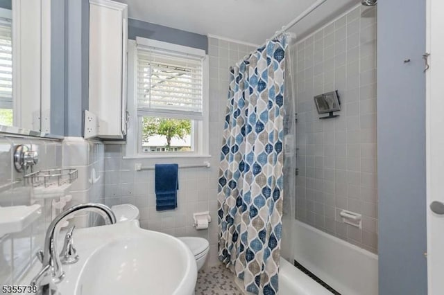 bathroom with a sink, plenty of natural light, shower / tub combo, and toilet