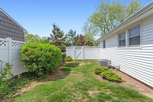 view of yard featuring a gate and central AC unit